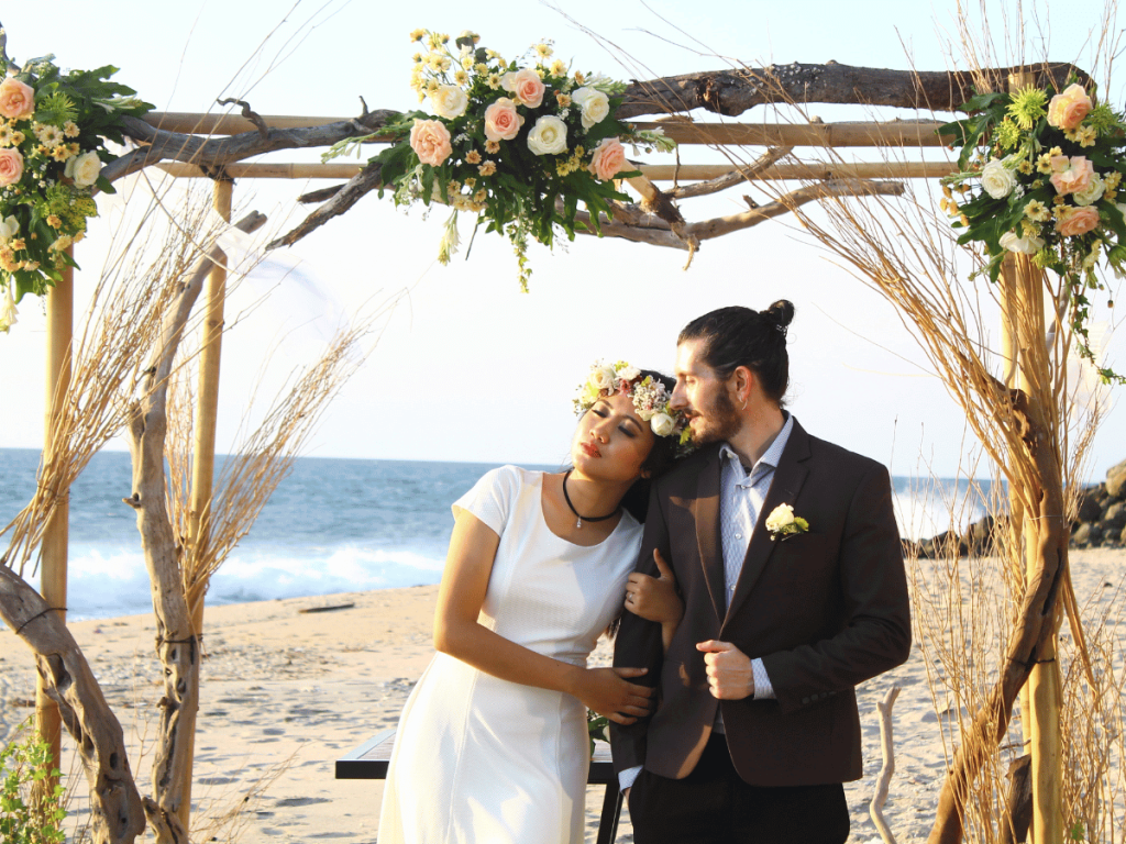 Pareja junto al arco nupcial en una boda de playa